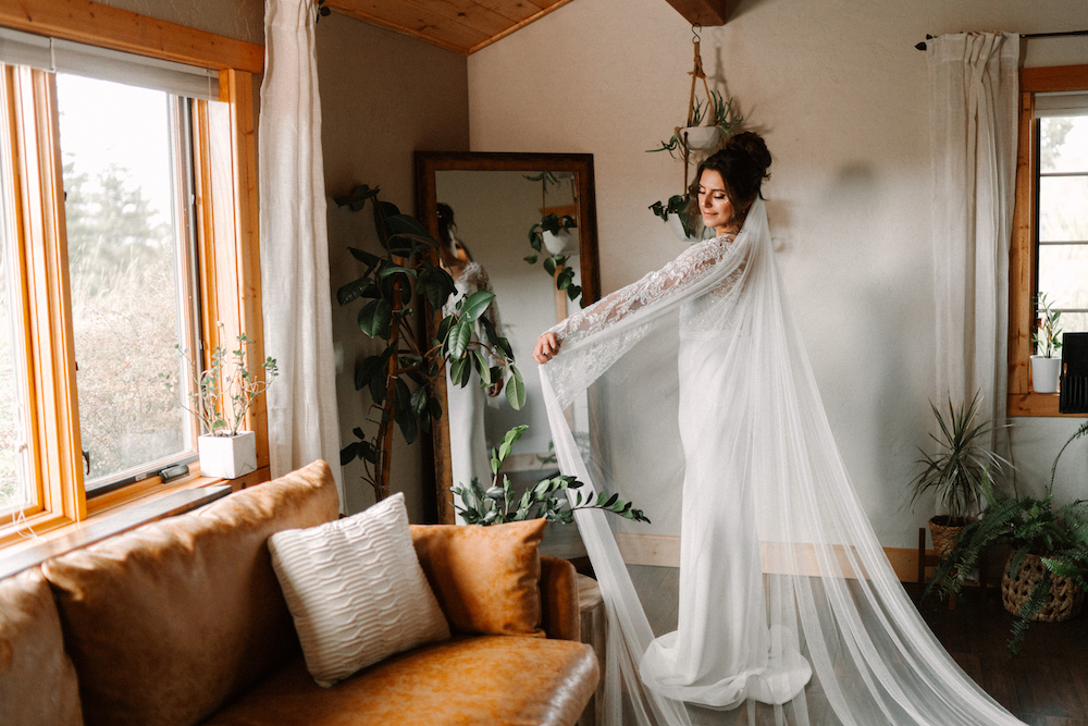 Bride Getting Ready in the Pikes Peak Getting Ready Suite Holding Up Her Veil In The Mirror