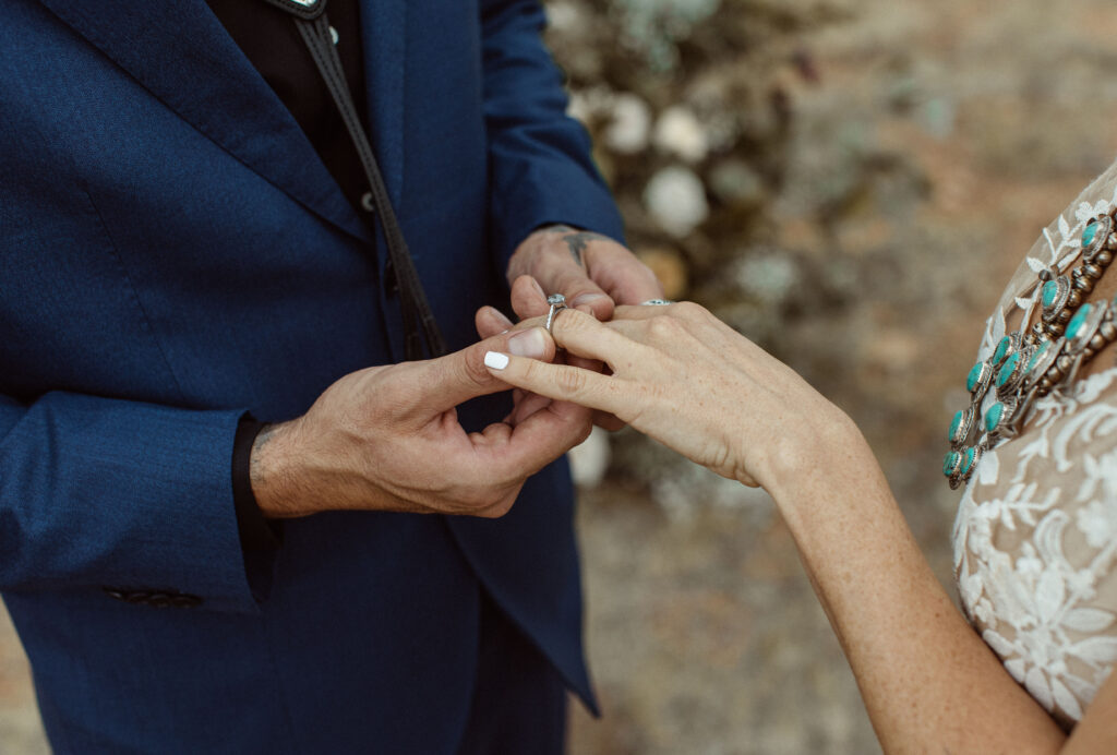 Groom putting ring on bride